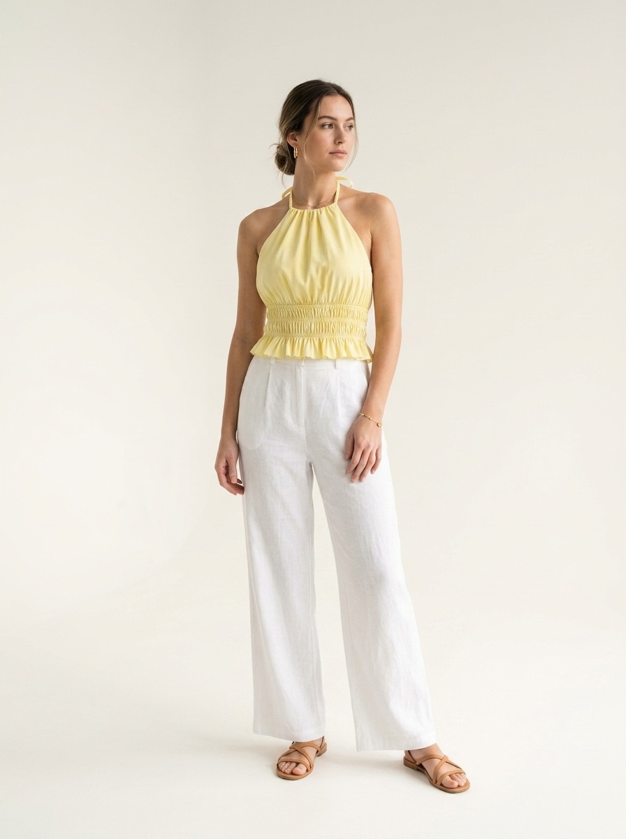 Elegante crop top giallo con scollo all'americana, orlo arricciato e volant.