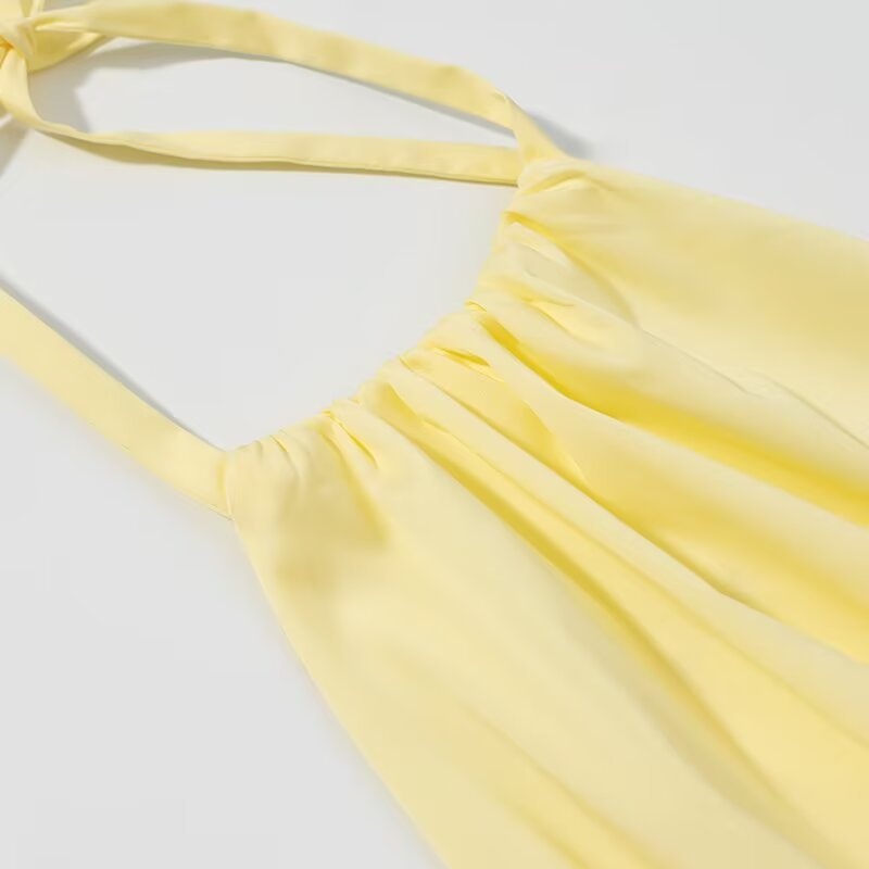 Elegante crop top giallo con scollo all'americana, orlo arricciato e volant.