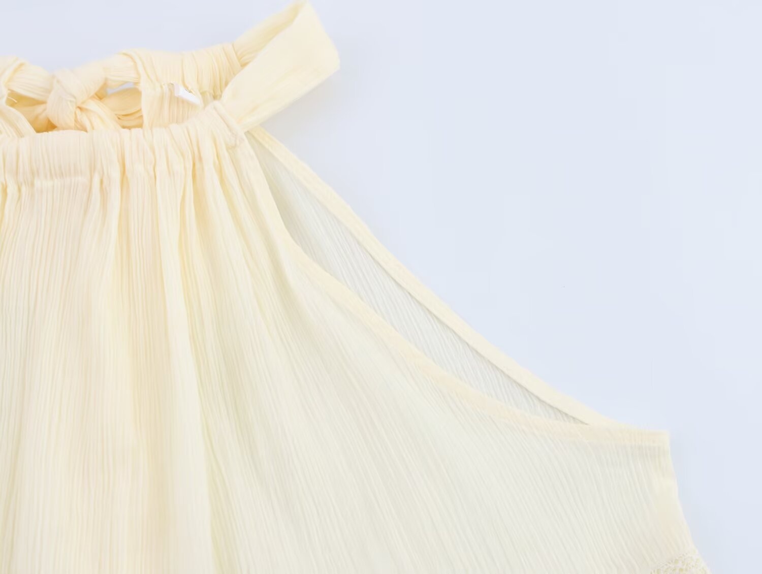 Elegante top all'americana in tessuto stropicciato con volant e finiture in pizzo.