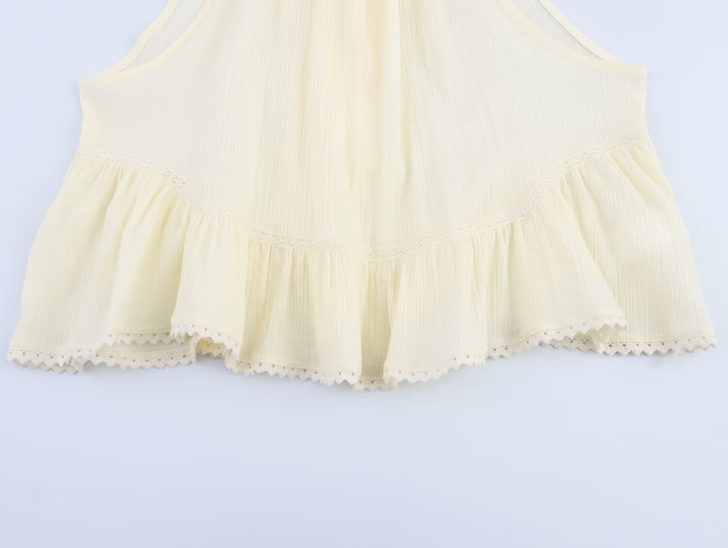 Elegante top all'americana in tessuto stropicciato con volant e finiture in pizzo.