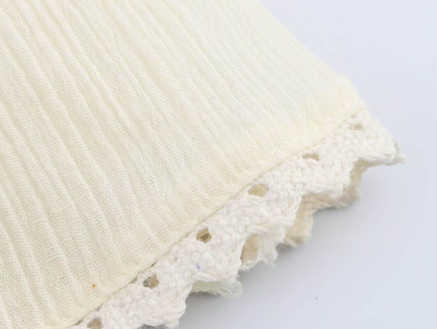 Elegante top all'americana in tessuto stropicciato con volant e finiture in pizzo.