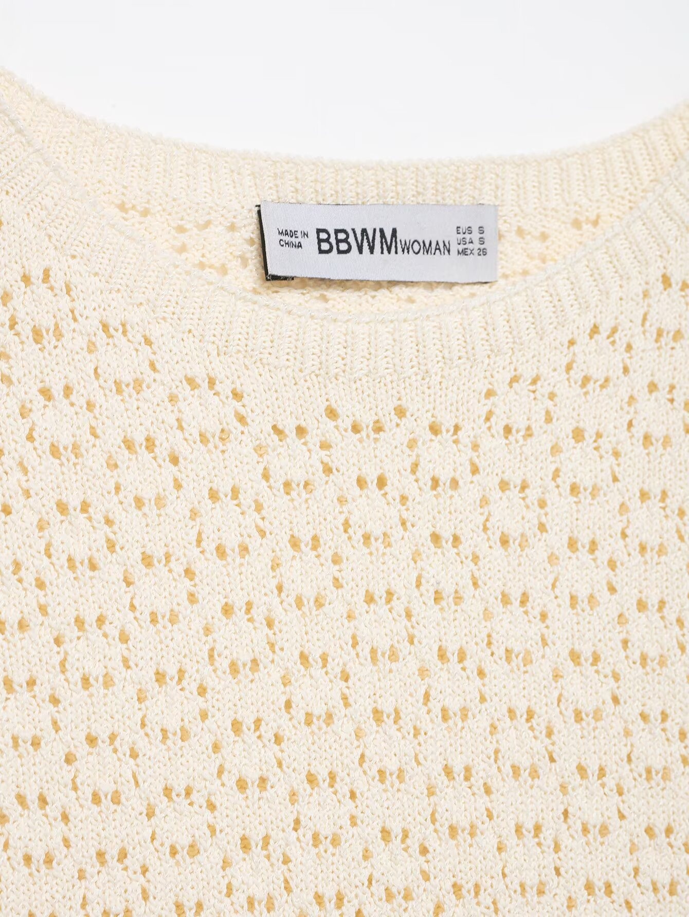 Elegante top in maglia con maniche a volant e dettagli traforati.