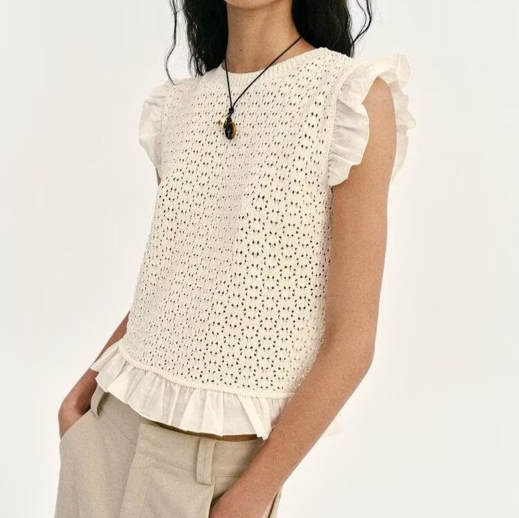 Elegante top in maglia con maniche a volant e dettagli traforati.