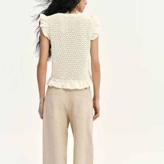 Elegante top in maglia con maniche a volant e dettagli traforati.