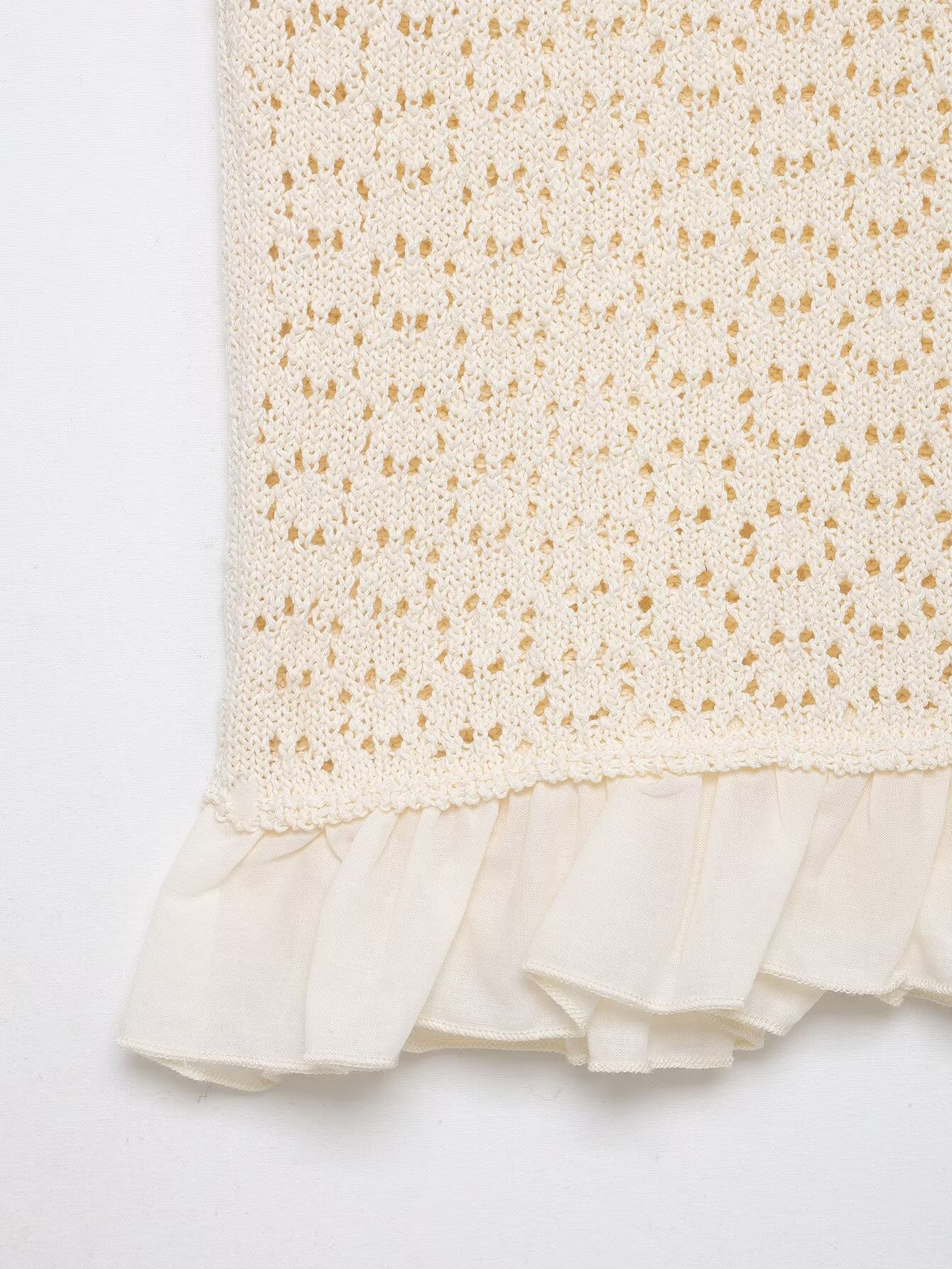 Elegante top in maglia con maniche a volant e dettagli traforati.