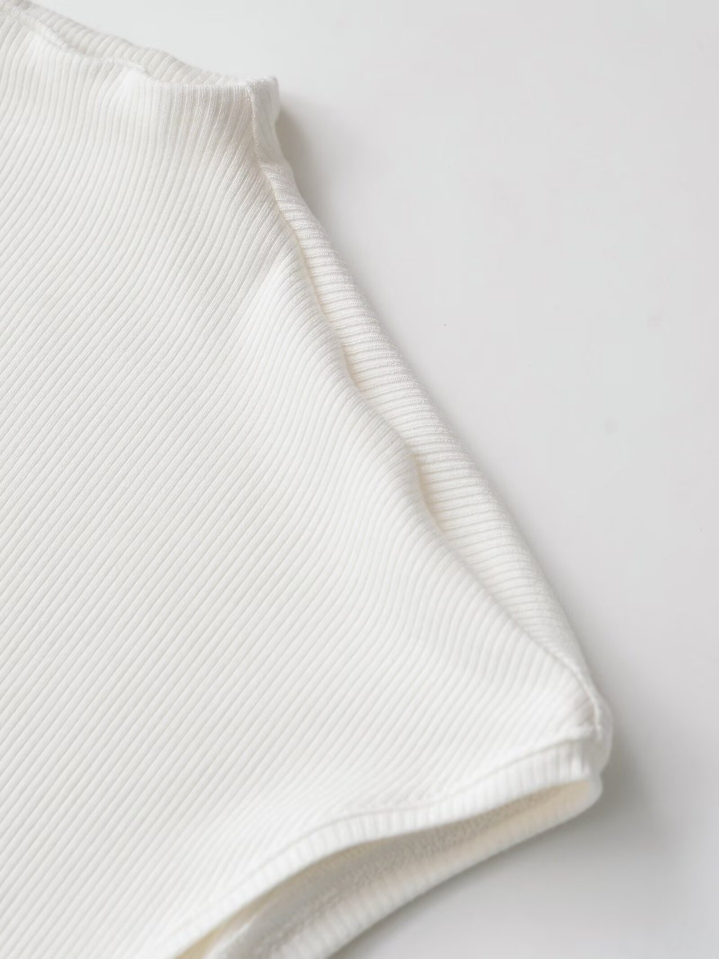 Elegante top bianco a coste con baschina - Chic senza maniche con collo alto
