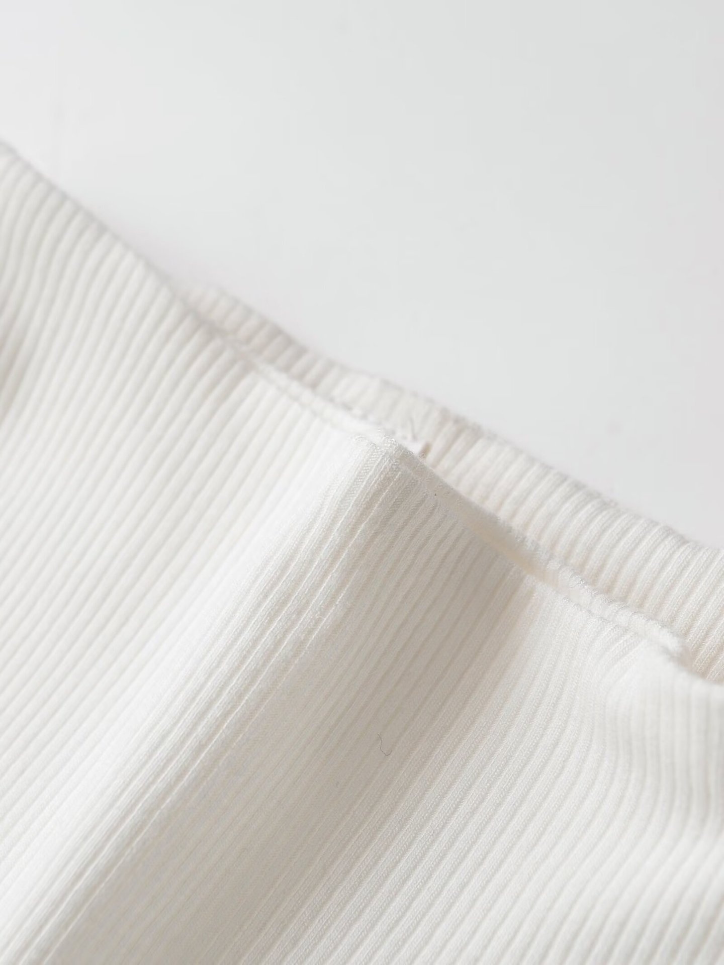 Elegante top bianco a coste con baschina - Chic senza maniche con collo alto