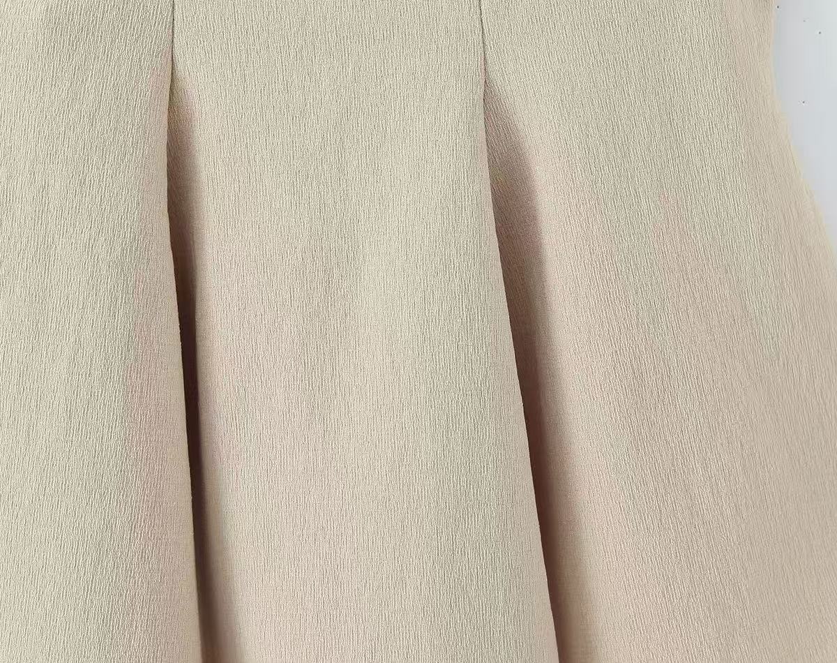 Elegante top a canotta beige plissettato con laccetti.