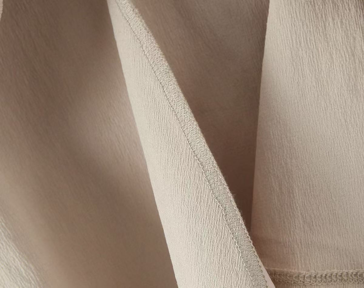 Elegante top a canotta beige plissettato con laccetti.