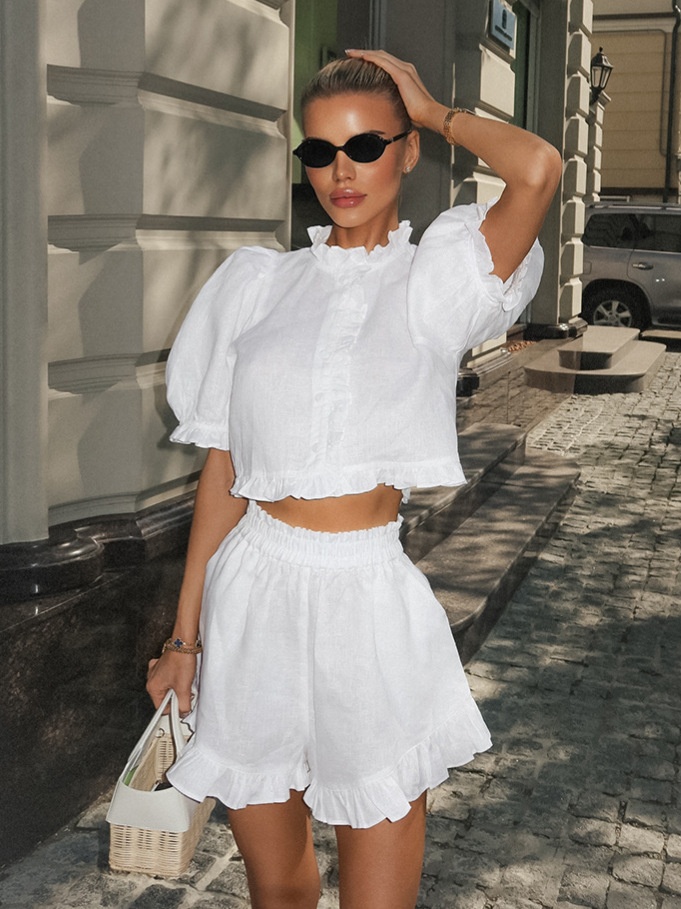 Completo due pezzi composto da top bianco con maniche a sbuffo e pantaloncini.