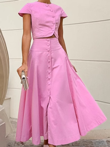 Ensemble deux pièces rose composé d'un crop top boutonné sur le devant et d'une jupe longue