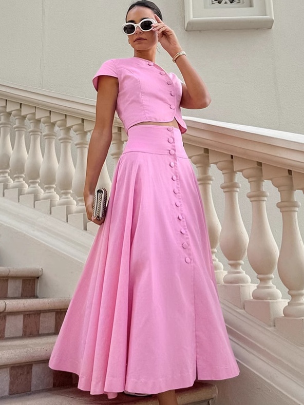 Ensemble deux pièces rose composé d'un crop top boutonné sur le devant et d'une jupe longue