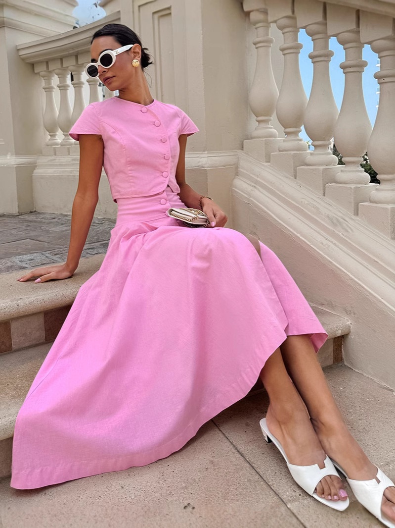 Ensemble deux pièces rose composé d'un crop top boutonné sur le devant et d'une jupe longue