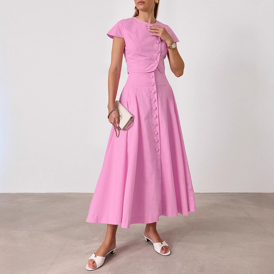 Ensemble deux pièces rose composé d'un crop top boutonné sur le devant et d'une jupe longue