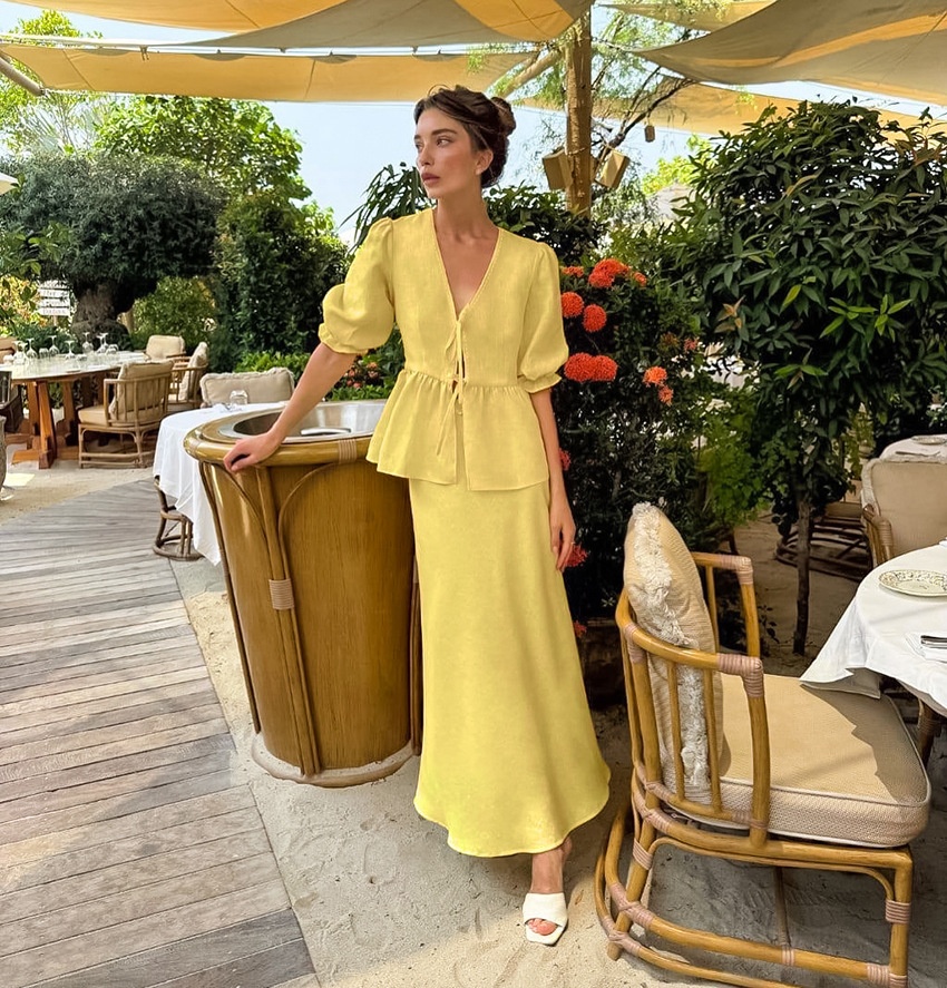 Completo giallo composto da top peplum con maniche a sbuffo e gonna lunga.