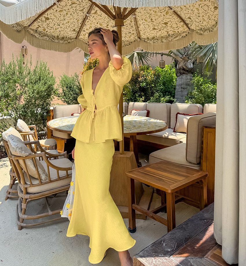 Completo giallo composto da top peplum con maniche a sbuffo e gonna lunga.
