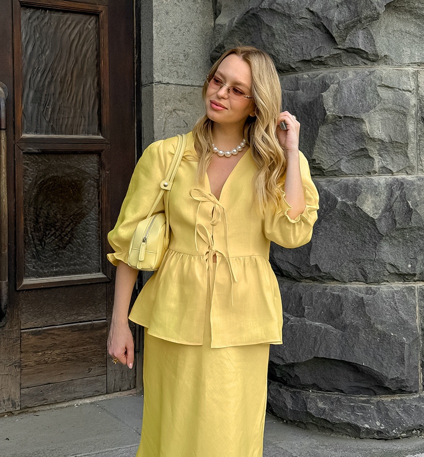 Completo giallo composto da top peplum con maniche a sbuffo e gonna lunga.