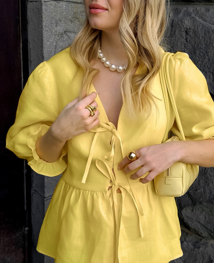 Completo giallo composto da top peplum con maniche a sbuffo e gonna lunga.