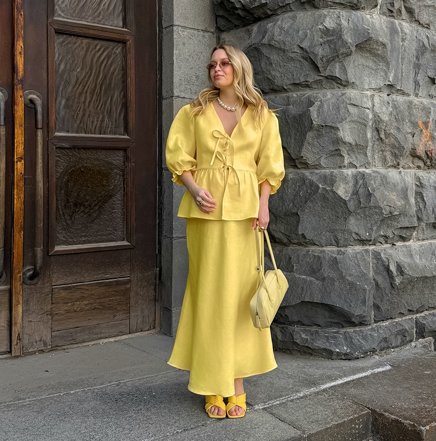 Completo giallo composto da top peplum con maniche a sbuffo e gonna lunga.