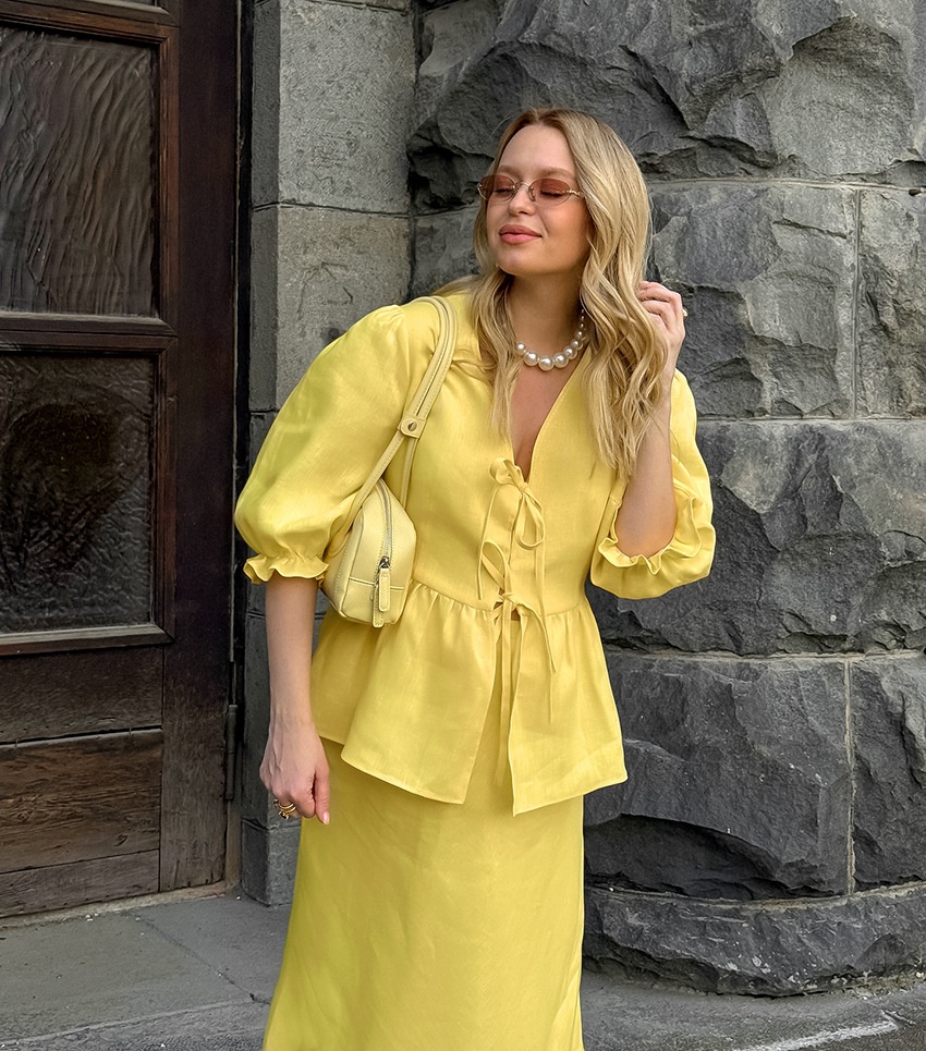 Completo giallo composto da top peplum con maniche a sbuffo e gonna lunga.