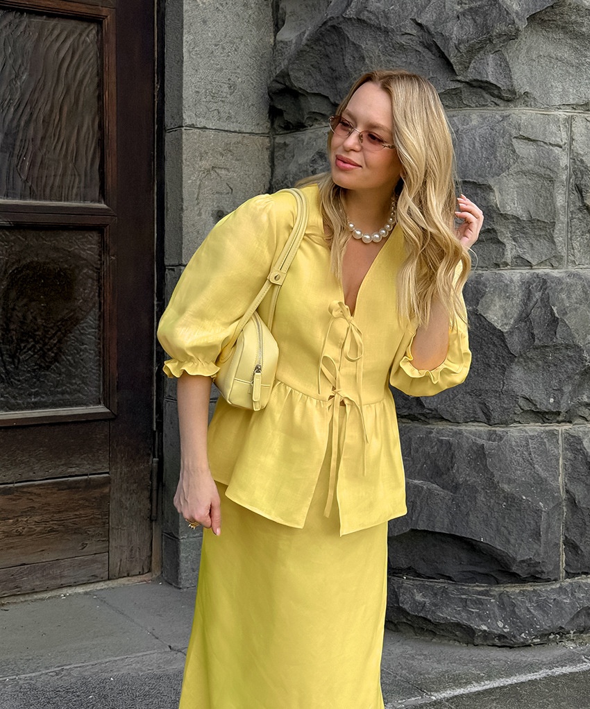 Completo giallo composto da top peplum con maniche a sbuffo e gonna lunga.
