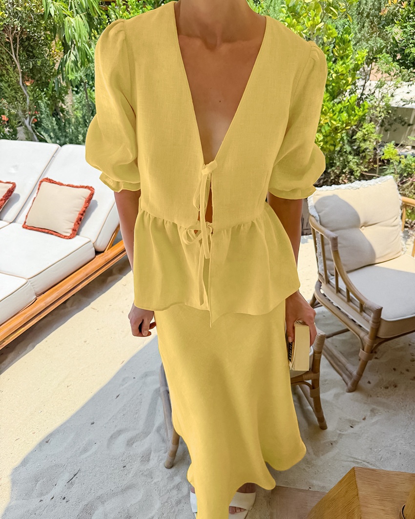Completo giallo composto da top peplum con maniche a sbuffo e gonna lunga.