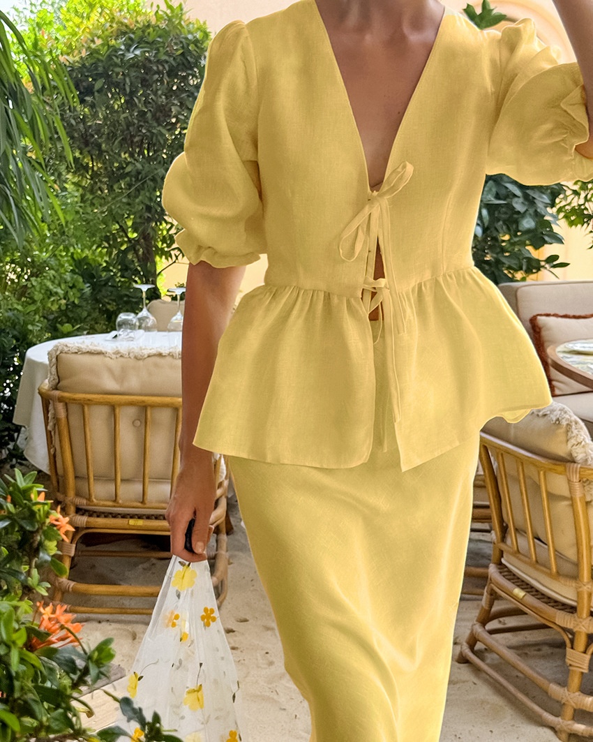 Completo giallo composto da top peplum con maniche a sbuffo e gonna lunga.