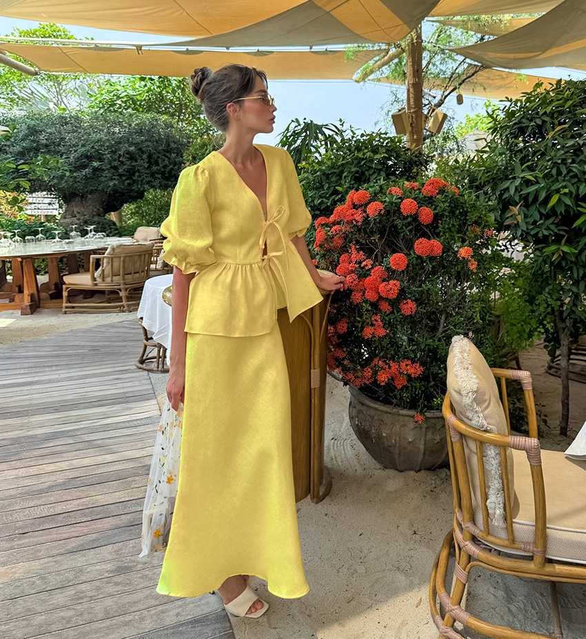 Completo giallo composto da top peplum con maniche a sbuffo e gonna lunga.