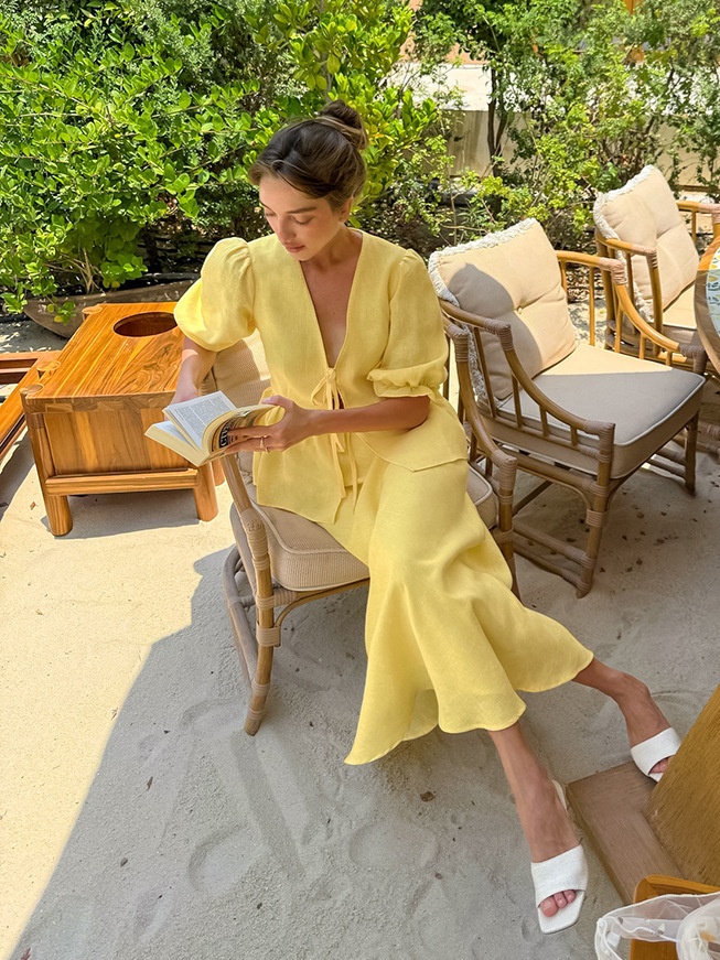 Completo giallo composto da top peplum con maniche a sbuffo e gonna lunga.