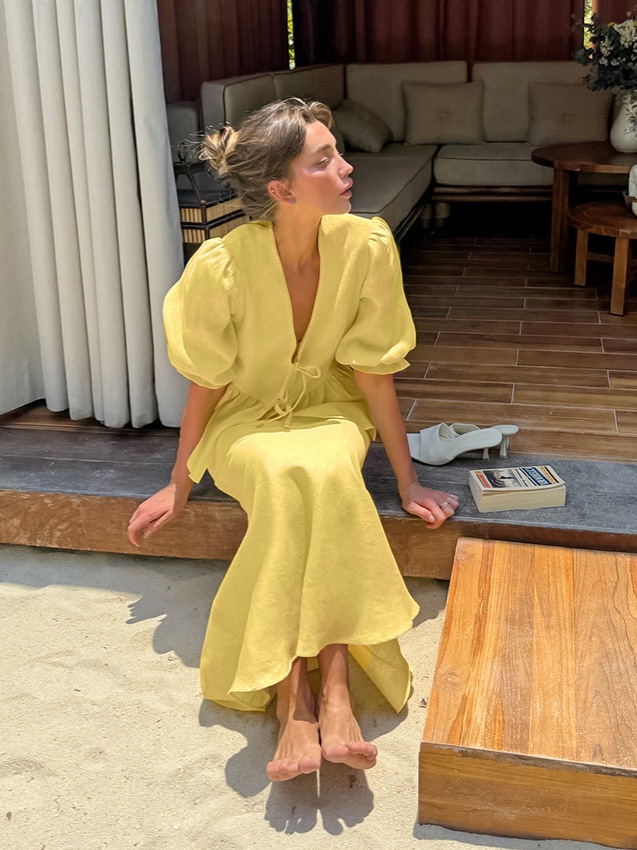 Completo giallo composto da top peplum con maniche a sbuffo e gonna lunga.