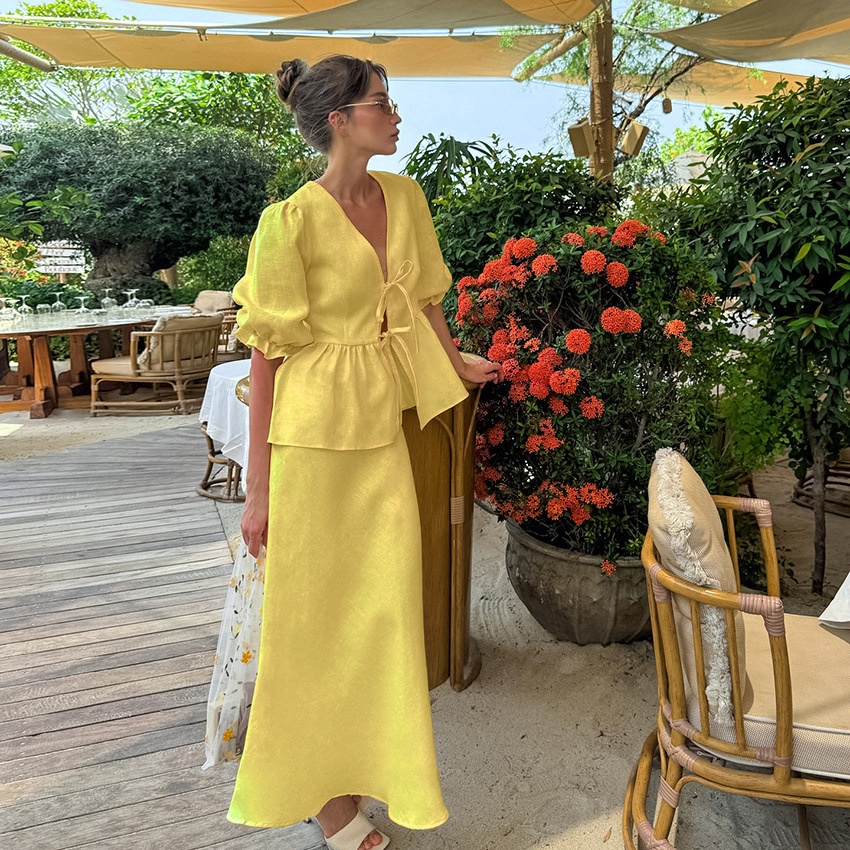 Completo giallo composto da top peplum con maniche a sbuffo e gonna lunga.