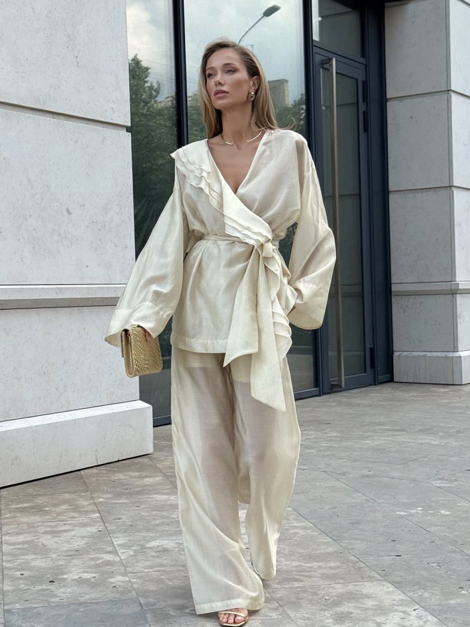 Completo da donna composto da blusa a portafoglio con volant e pantaloni a gamba larga.