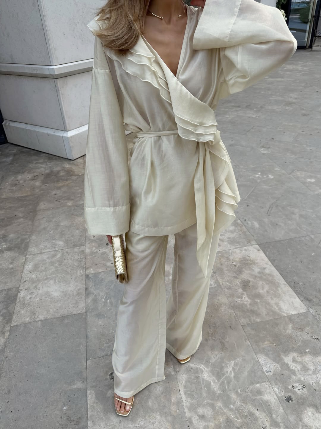 Completo da donna composto da blusa a portafoglio con volant e pantaloni a gamba larga.