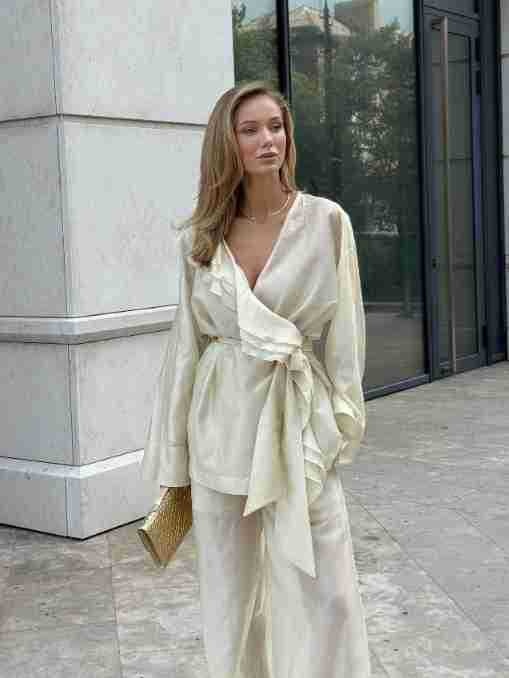 Completo da donna composto da blusa a portafoglio con volant e pantaloni a gamba larga.