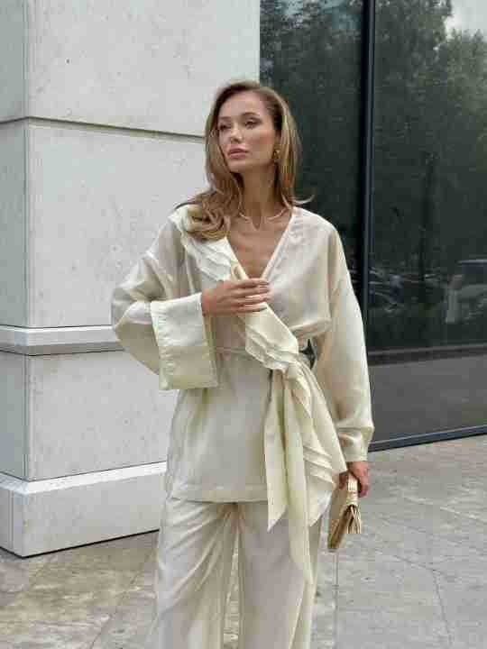Completo da donna composto da blusa a portafoglio con volant e pantaloni a gamba larga.
