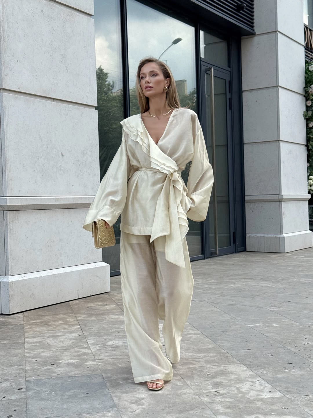 Completo da donna composto da blusa a portafoglio con volant e pantaloni a gamba larga.