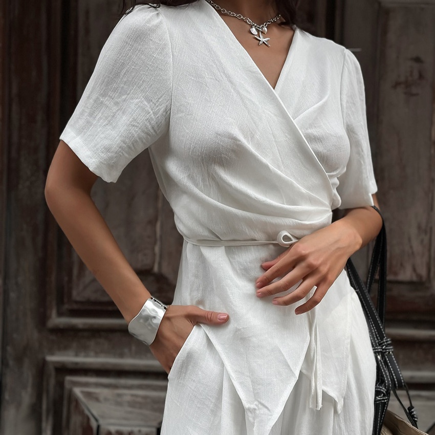 Completo da donna composto da top a portafoglio bianco e pantaloni a gamba larga.