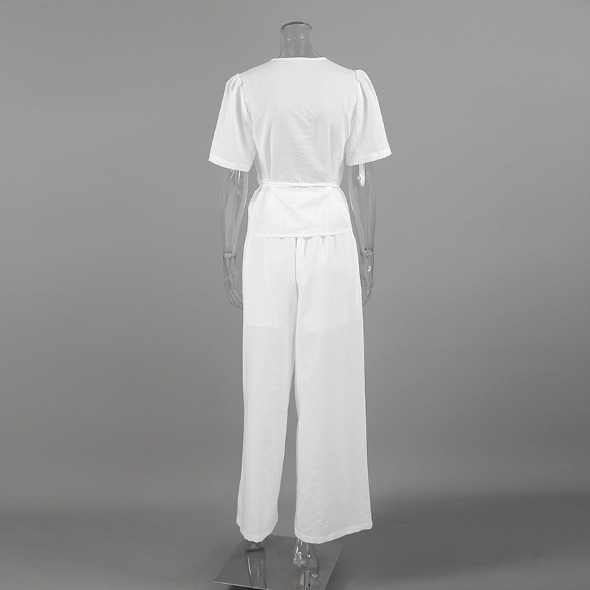 Completo da donna composto da top a portafoglio bianco e pantaloni a gamba larga.