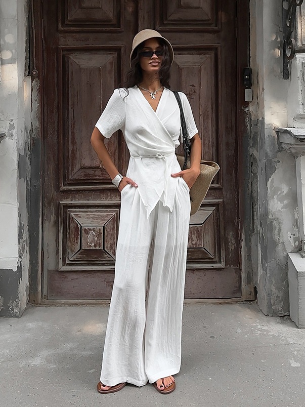 Completo da donna composto da top a portafoglio bianco e pantaloni a gamba larga.
