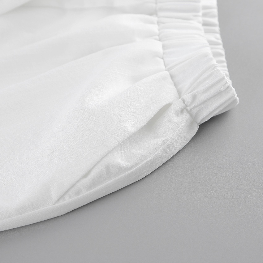 Completo da donna composto da top a portafoglio bianco e pantaloni a gamba larga.