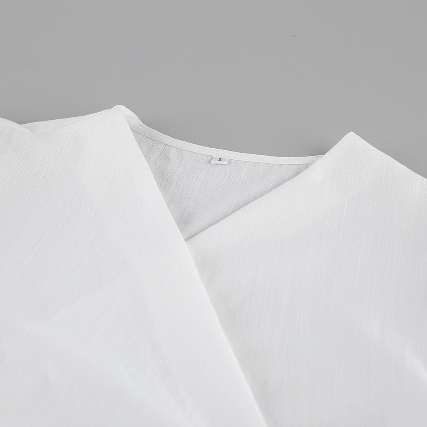 Completo da donna composto da top a portafoglio bianco e pantaloni a gamba larga.