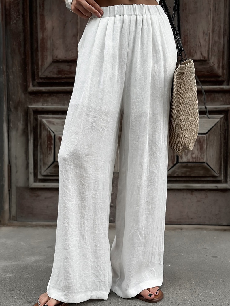 Completo da donna composto da top a portafoglio bianco e pantaloni a gamba larga.