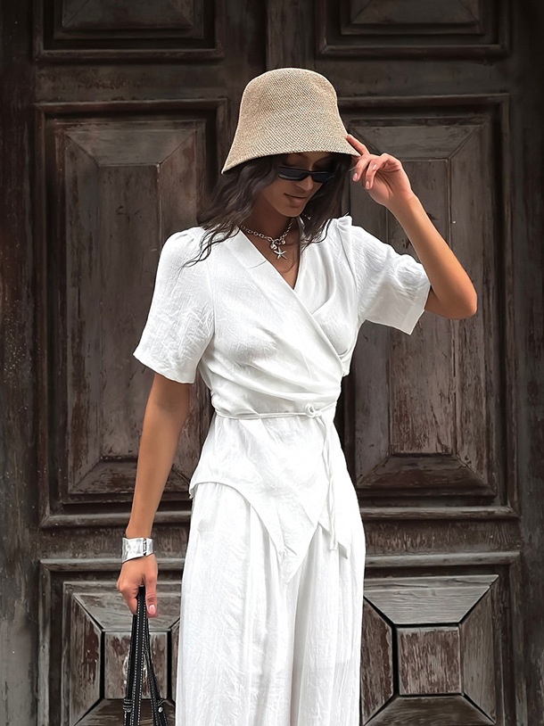 Completo da donna composto da top a portafoglio bianco e pantaloni a gamba larga.