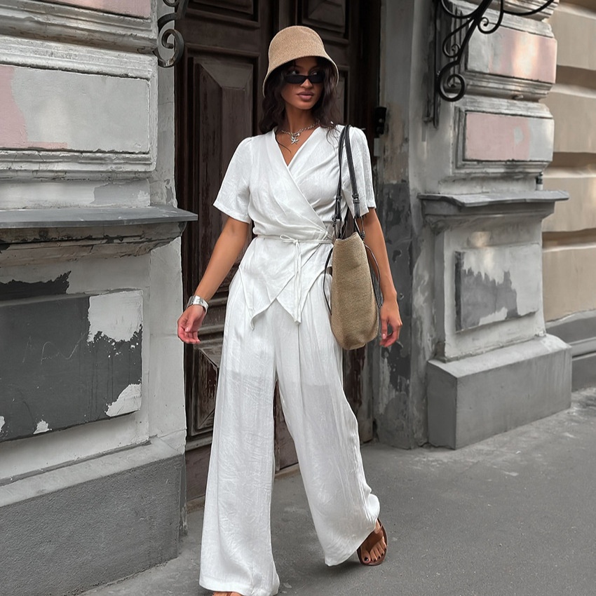 Completo da donna composto da top a portafoglio bianco e pantaloni a gamba larga.
