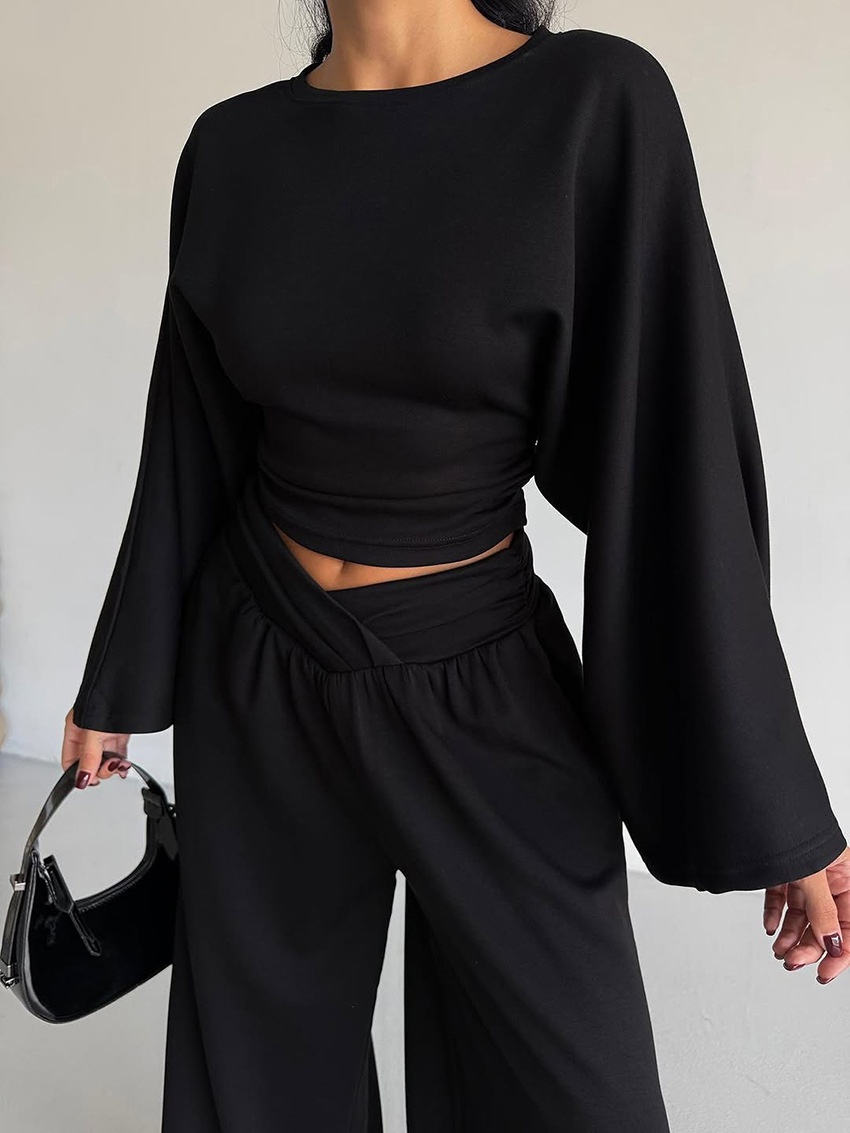 Completo composto da pantaloni a gamba larga e top corto a maniche lunghe.