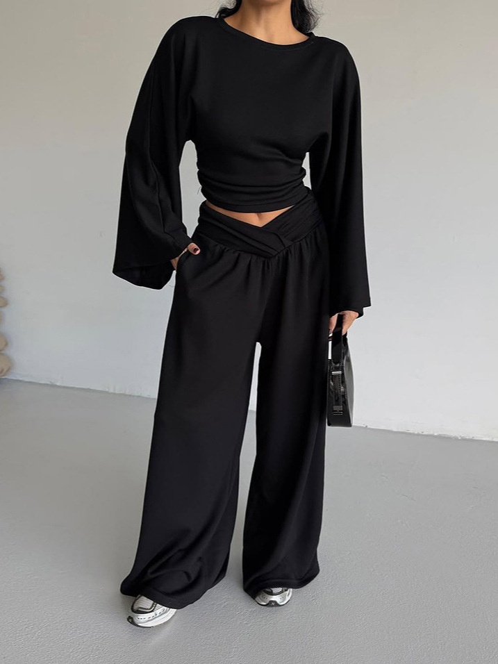 Completo composto da pantaloni a gamba larga e top corto a maniche lunghe.