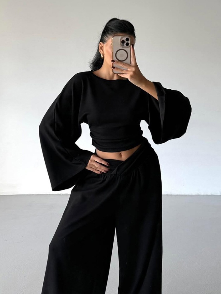 Completo composto da pantaloni a gamba larga e top corto a maniche lunghe.