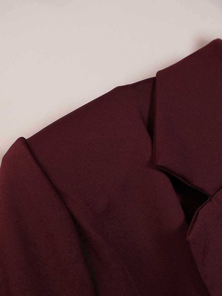 Completo da donna composto da blazer aderente e pantaloni a gamba larga color marrone scuro.