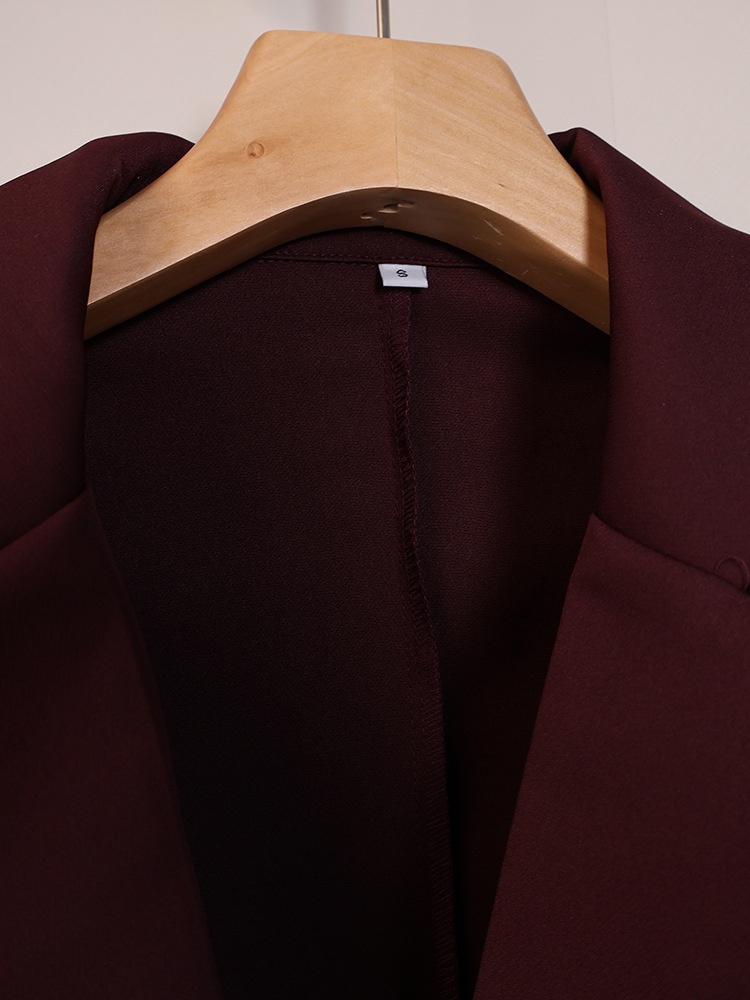 Completo da donna composto da blazer aderente e pantaloni a gamba larga color marrone scuro.