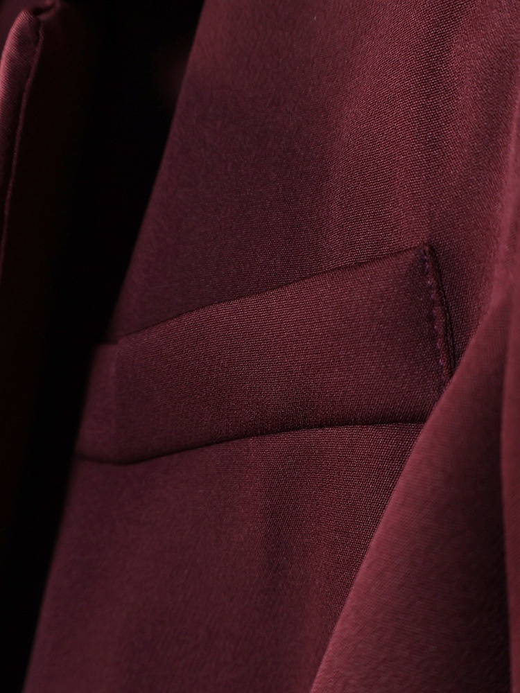 Completo da donna composto da blazer aderente e pantaloni a gamba larga color marrone scuro.